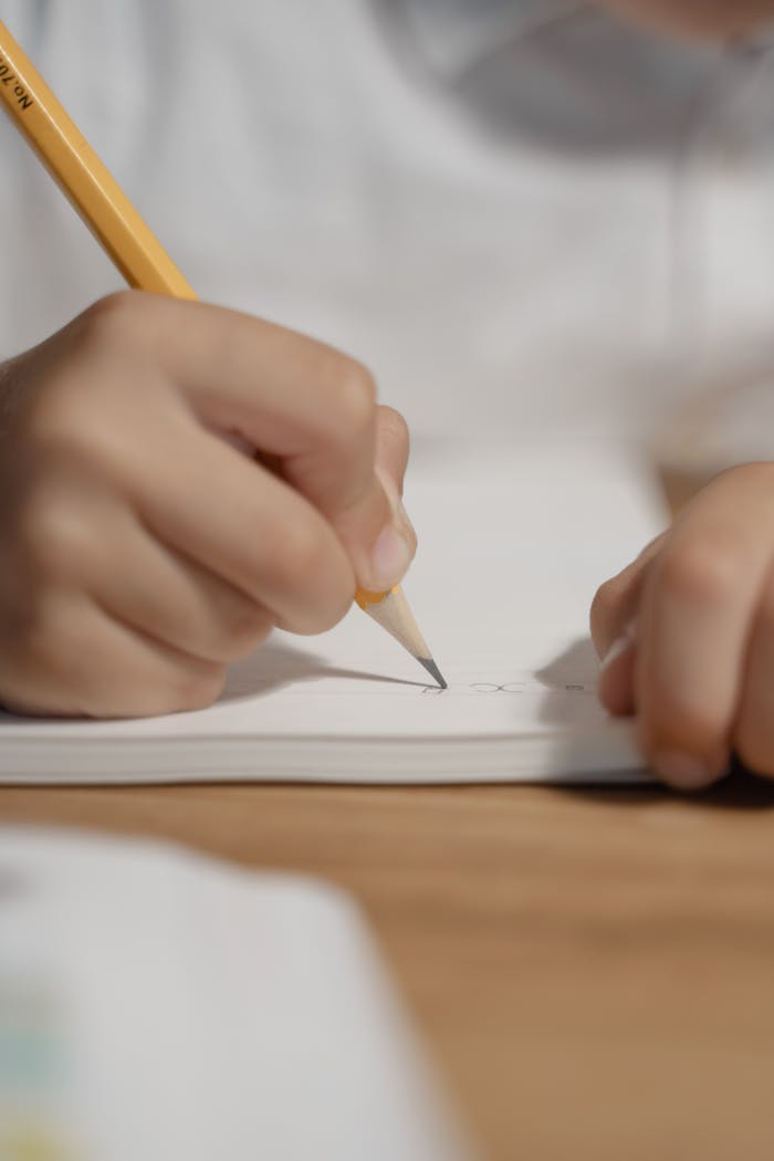 A Person Writing on a Notebook